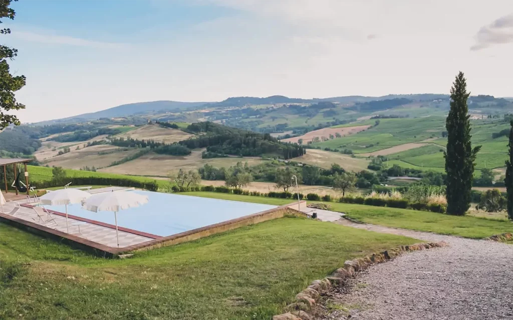 Aerial view of an agritourismo's pool surrounded by lush Tuscan countryside
