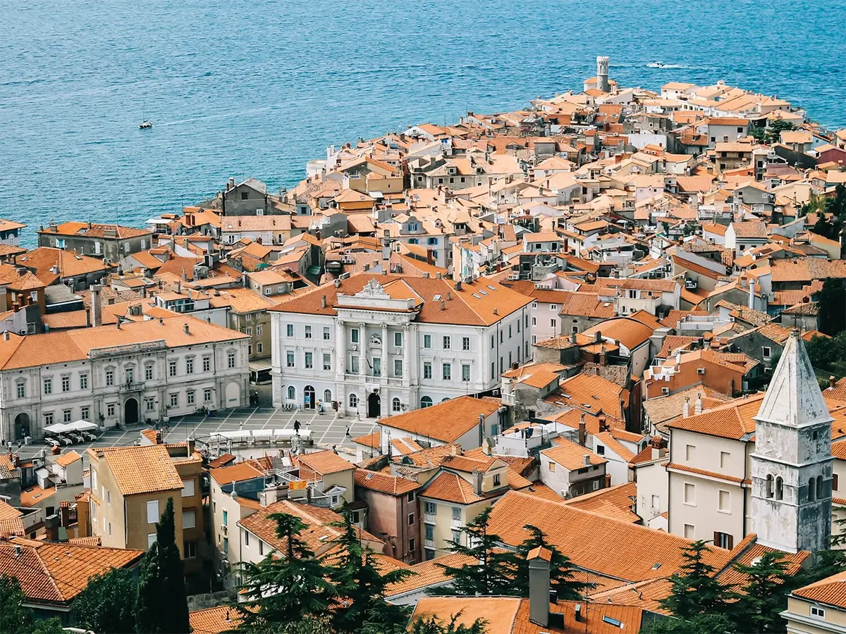 Piran: Slovenia's Enchanting Adriatic Jewel 1 Aerial view of Piran peninsula extending into the Adriatic Sea, showcasing terracotta rooftops and historic architecture