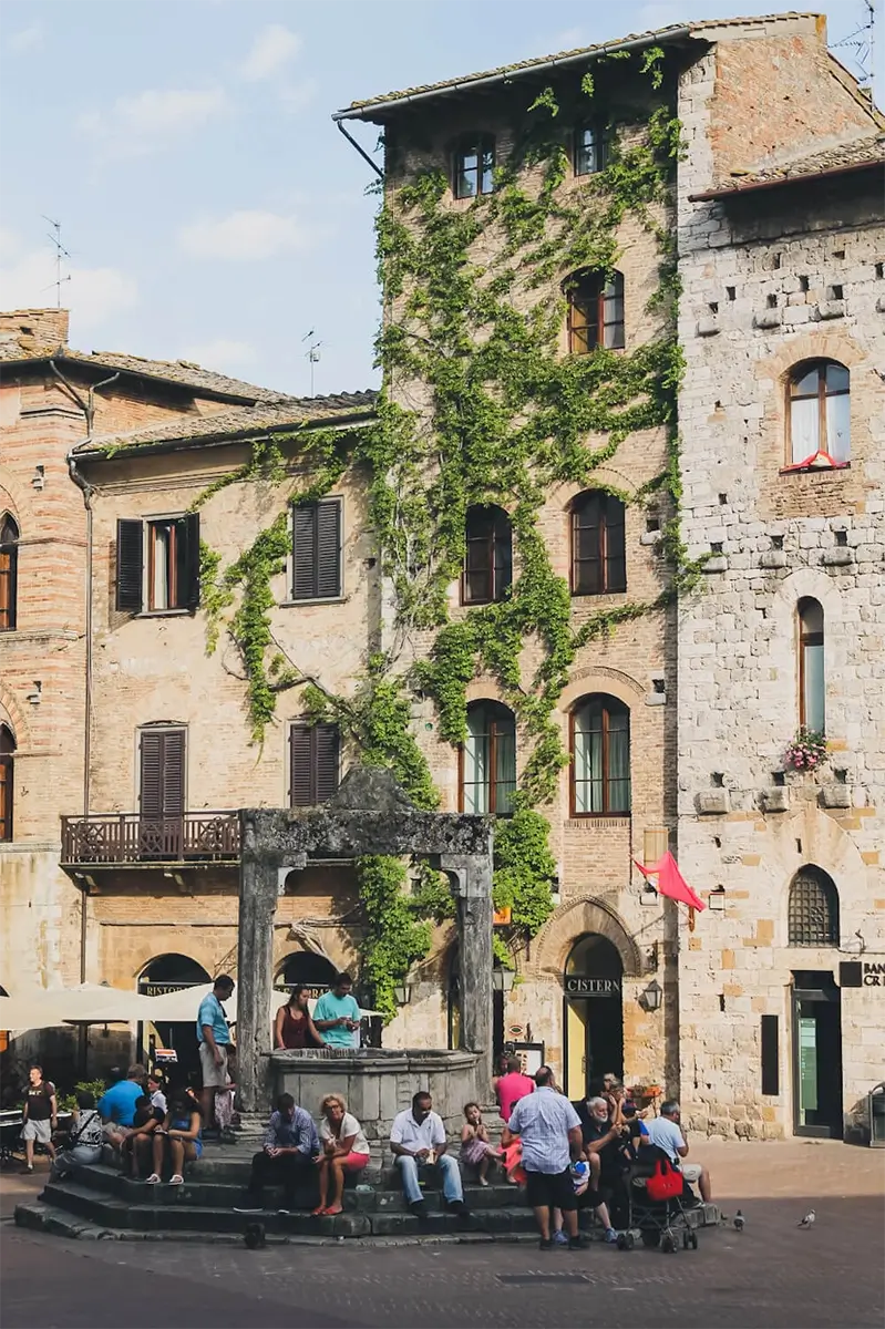 San Gimignano Travel Guide: Best Things to Do and See in Tuscany’s Tower Town 2 Charming medieval street scene in San Gimignano, showcasing historic architecture under a blue sky.
