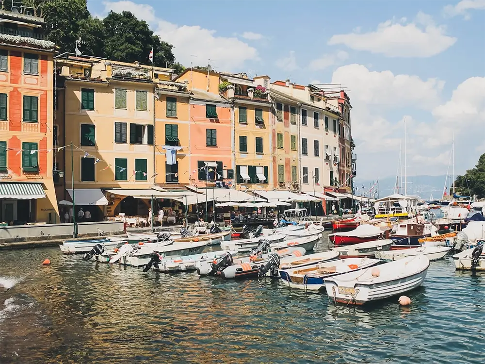 Why Should You Visit Portofino on the Italian Riviera? 3 Colorful buildings lining the harbor of Portofino with boats docked along the waterfront