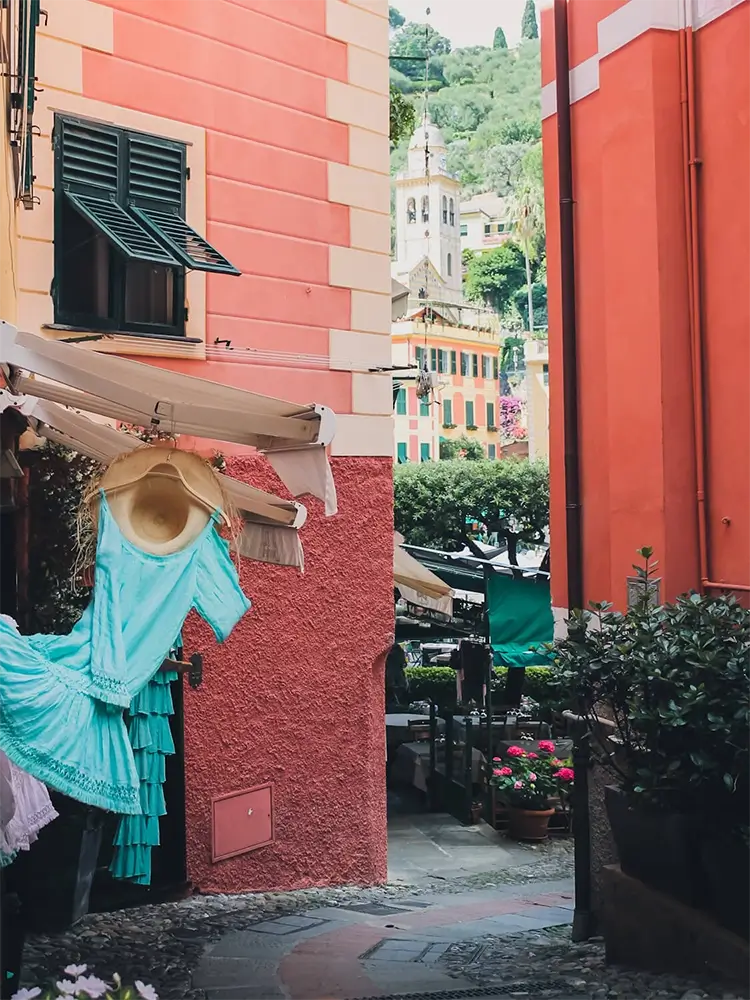 Charming narrow street in Portofino lined with pastel-colored buildings and shops.