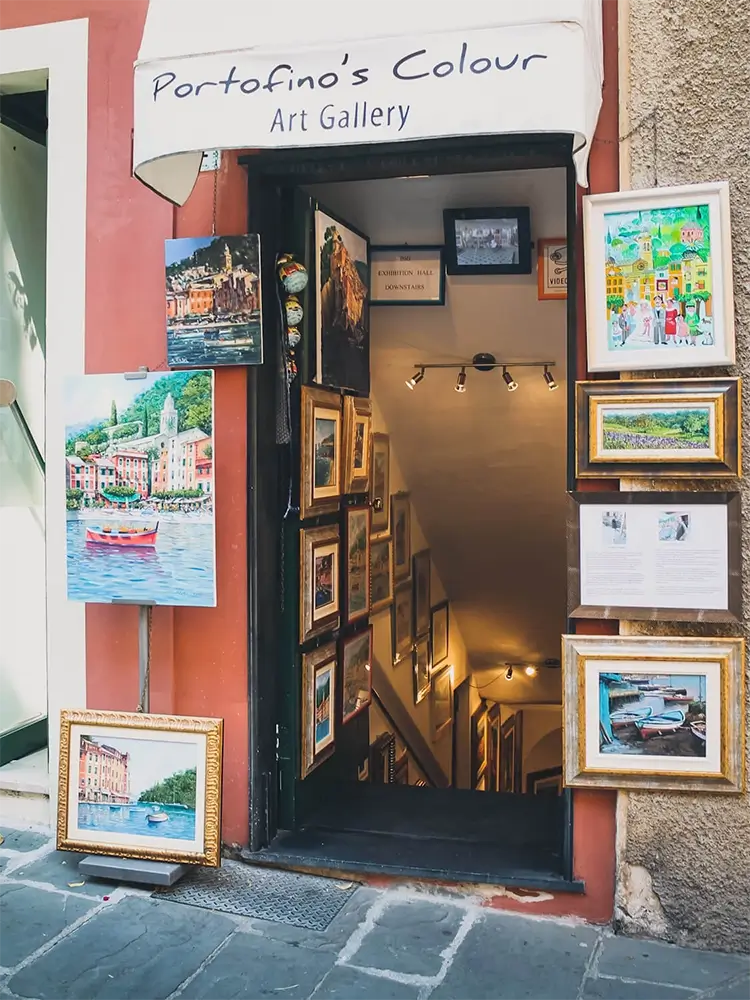 Charming narrow street in Portofino lined with pastel-colored buildings and shops.