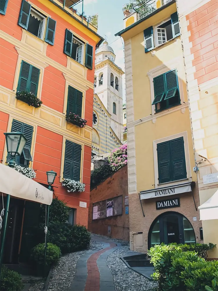 Charming narrow street in Portofino lined with pastel-colored buildings and shops.